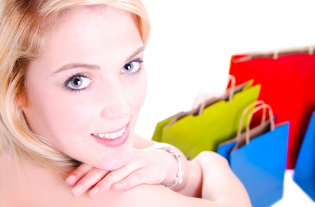 Beauty shot of a young gorgeous woman looking over her shoulder whit shopping bags in the groundの写真素材