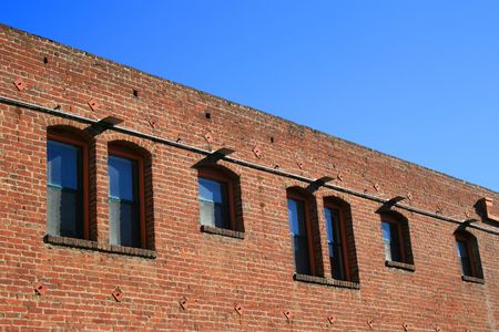 Old red brick building over blue sky.