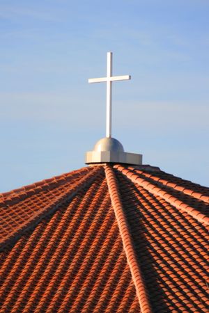 Cross on top of a church over blue sky.の写真素材