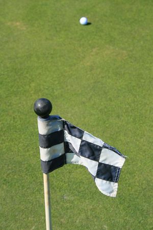 Close up of a golf course flag and a golf ball.の写真素材