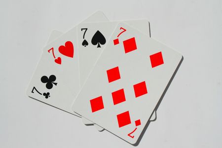 Close up of four sevens on a white background.