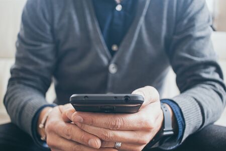 man with smartphone on the sofaの写真素材