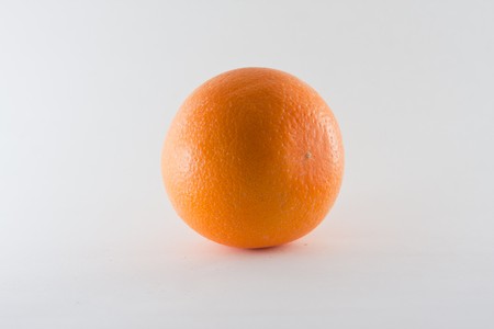 an orange on a table with white backgroundの写真素材