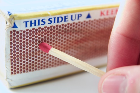 Person about to light a match on the side of a matchboxの写真素材