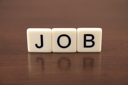 JOB spelled from letter tiles on a wooden backgroundの写真素材