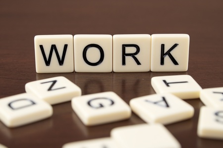 WORK spelled from letter tiles on a wooden backgroundの写真素材