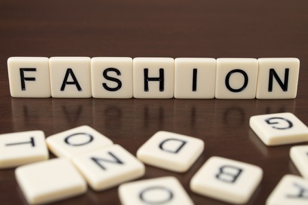 FASHION spelled from letter tiles on a wooden backgroundの写真素材