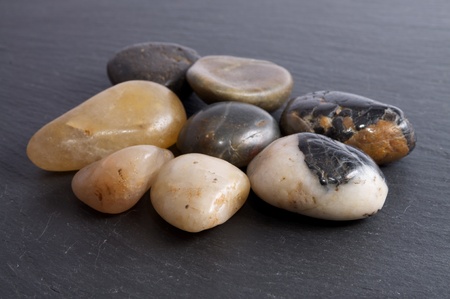 Group of river stones on a black slate backgroundの写真素材