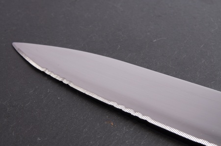 Serrated knife on a slate cutting boardの写真素材