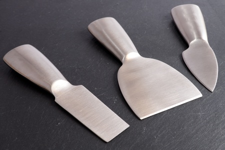 Stainless steel cheese cutting tools on a slate backgroundの写真素材
