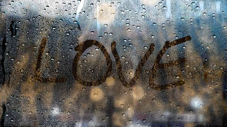 heart drawn on a window wet from the rainの写真素材