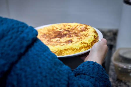 unrecognizable woman holding a spanish potato omelette.の写真素材