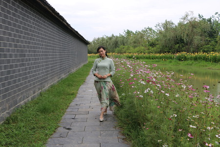 Woman hand holding a flower and walking on the pave way in the parkの写真素材