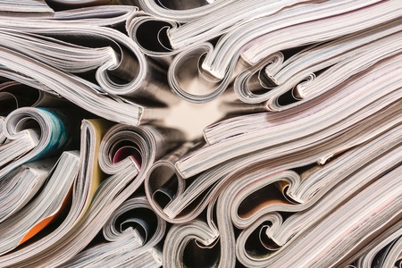 Several magazines opened and then stacked in forming stacks of paper with curlsの写真素材