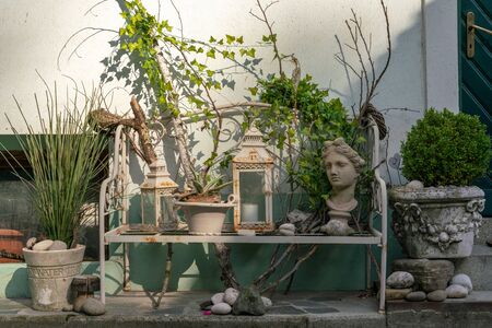 Various decorative objects with vintage aesthetics on a bench located on a sidewalkの写真素材