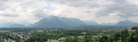 Panorama view of the mountain range from Salzburg on a cloudy dayの写真素材