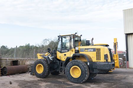 Mallorca, Spain - December 07, 2019: Komatsu excavator tractor machine vehicle, in yellow color.