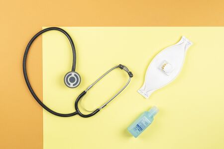Medical utensils kit: a stethoscope, a mask and a hands cleaning. Text in spanish: Gel hand cleaner with alcohol, without water.の写真素材
