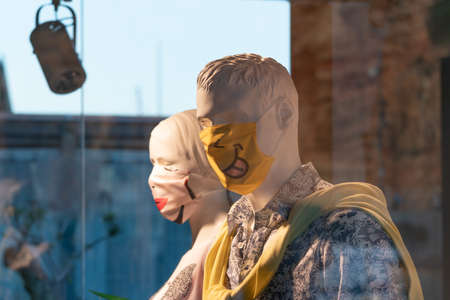 Calvia, Majorca, Spain - June 1, 2020: two mannequins, male and female, in a luxury brand fashion store, with a medical mask designed during the coronavirus crisisのeditorial素材