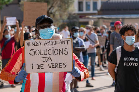 Palma, Majorca, Spain - June 7, 2020: black immigrant demanding solutions to the problem of street vending, text in Catalanのeditorial素材