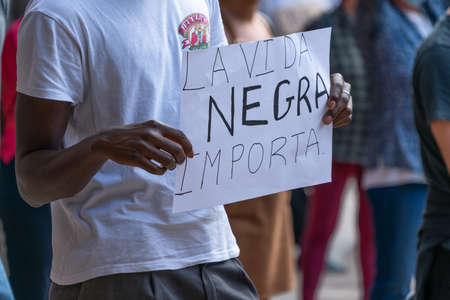 Palma, Majorca, Spain - June 7, 2020: Black man holding protest banner during anti-racism...