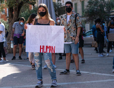 Palma, Majorca, Spain - June 7, 2020: young girl holding a banner at the anti-racism demonstration