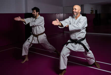 Karate master and his apprentice practicing martial arts attack in their dojoの写真素材