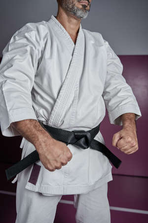 Karate master in powerful position, practicing martial arts in his dojo