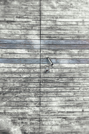 Old barn door with peeling paint textured in grungy grey tones with three boards highlighted in blue details.の写真素材