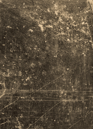 Abstract background textured in dark grey and sepia with scratches and stains.の写真素材