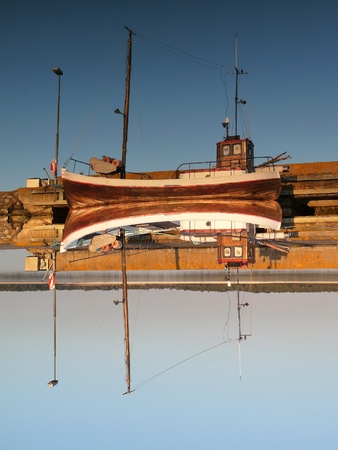 Fishing boat at the harbour with reflection in the water at Gotland, Sweden.の写真素材