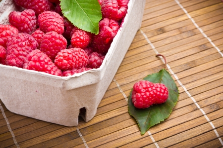 Delicious sweet raspberries on wooden background
