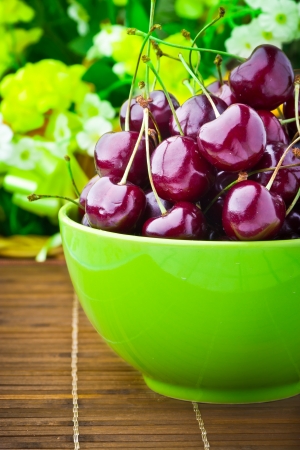Sweet cherry fruits in colorful bowlの写真素材