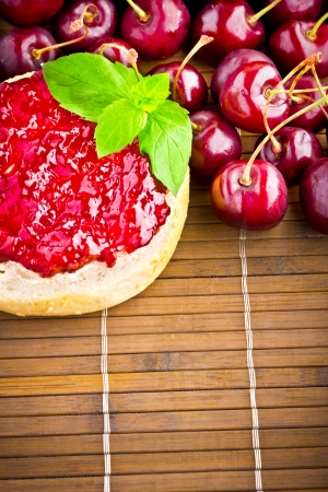 Delicious roll with cherry jam and fresh fruits for breakfastの写真素材