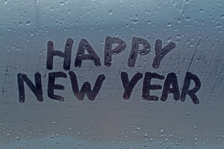 The inscription "happy new year" on the misted windowの写真素材