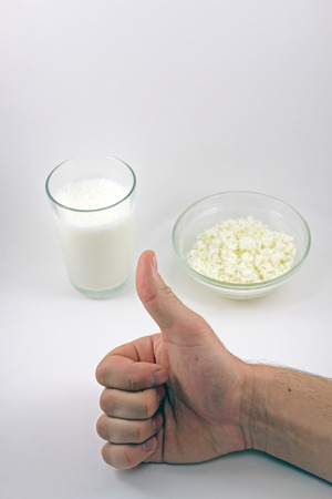 Thumbs up man's hand on the background of cottage cheese and kefirの写真素材