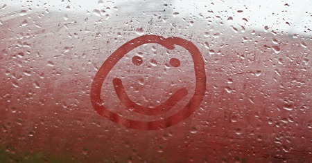 Smile on the misted windowの写真素材