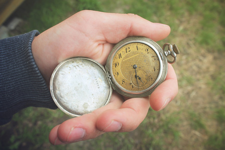 Old pocket watch in a man's handの写真素材