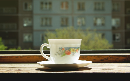 White cup of coffee on old wooden windowsillの写真素材