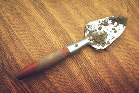 A small shovel on a wooden backgroundの写真素材