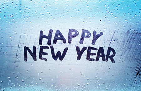The inscription "happy new year" on the misted windowの写真素材