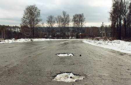 Large pit on the old road in the winterの写真素材