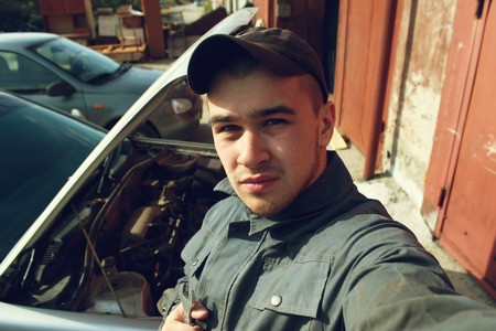 Auto mechanic photographs himselfの写真素材