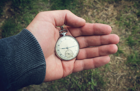 Vintage pocket watch in a man's handの写真素材