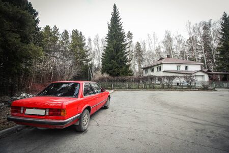 Lonely red car in a villageの写真素材