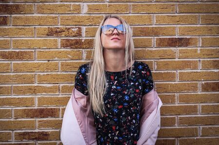 Young girl on a brick wall backgroundの写真素材