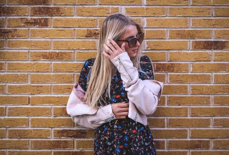 Young girl on a brick wall backgroundの写真素材