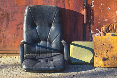 Old shabby armchair in the dumpの写真素材
