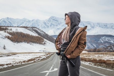 Girl on the background of mountains in winterの写真素材