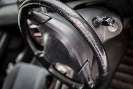 Threadbare automotive black leather steering wheel of old auto close-upの写真素材